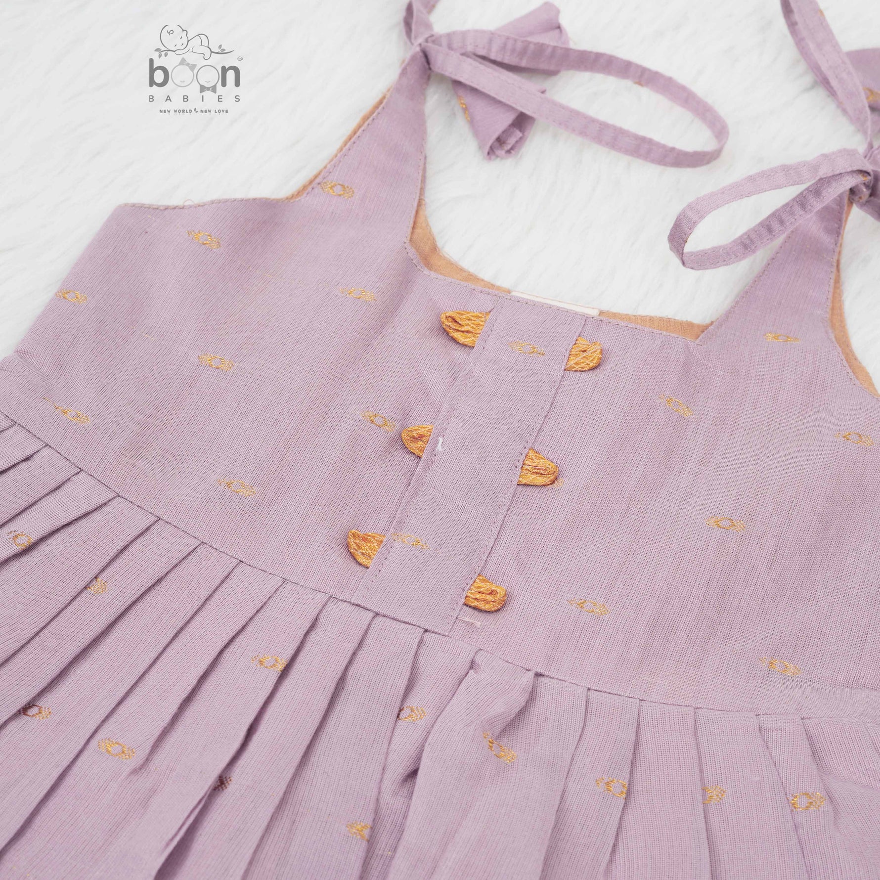 Elegant mauve silk knot frock with zari border for baby girls (0–12 months). Festive & comfortable – perfect for Onam celebrations.