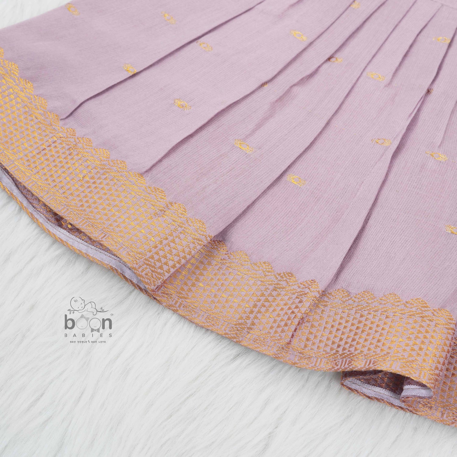 Elegant mauve silk knot frock with zari border for baby girls (0–12 months). Festive & comfortable – perfect for Onam celebrations.