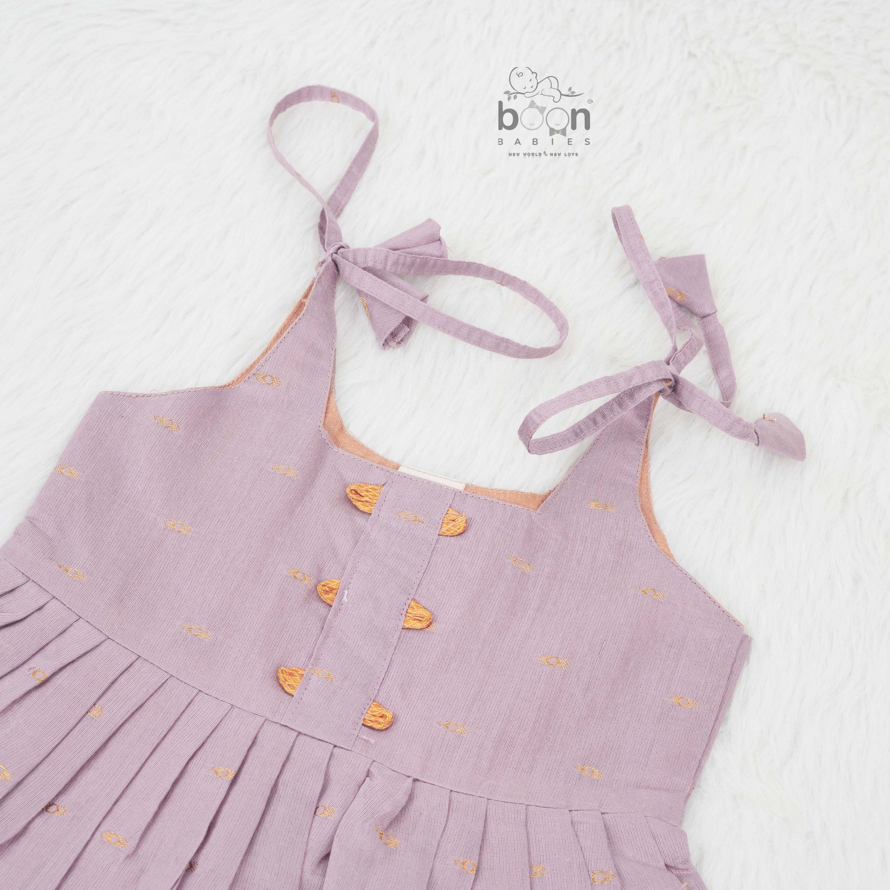 Elegant mauve silk knot frock with zari border for baby girls (0–12 months). Festive & comfortable – perfect for Onam celebrations.