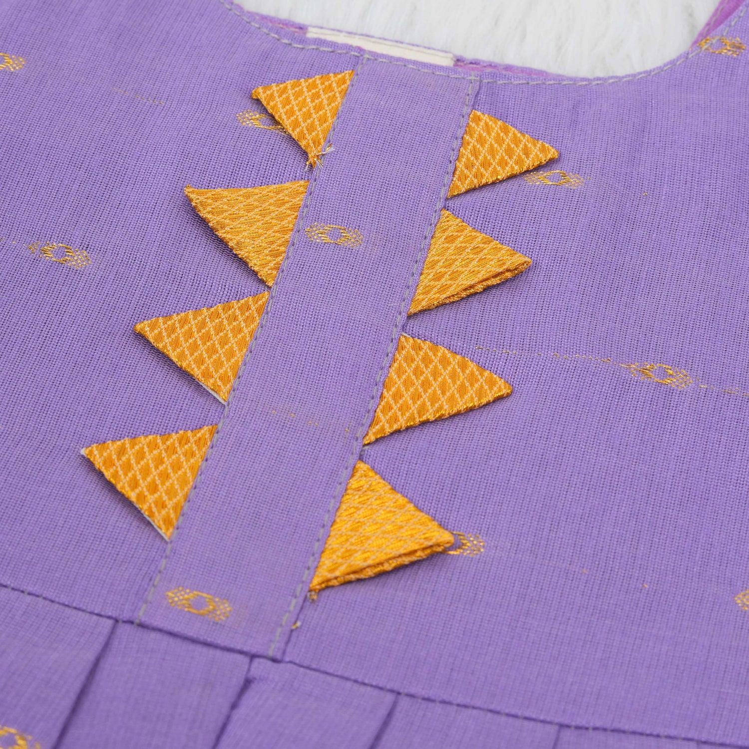 Festive purple silk Onam knot frock with triangle yoke design & zari border. Perfect for baby girls (0–12M).