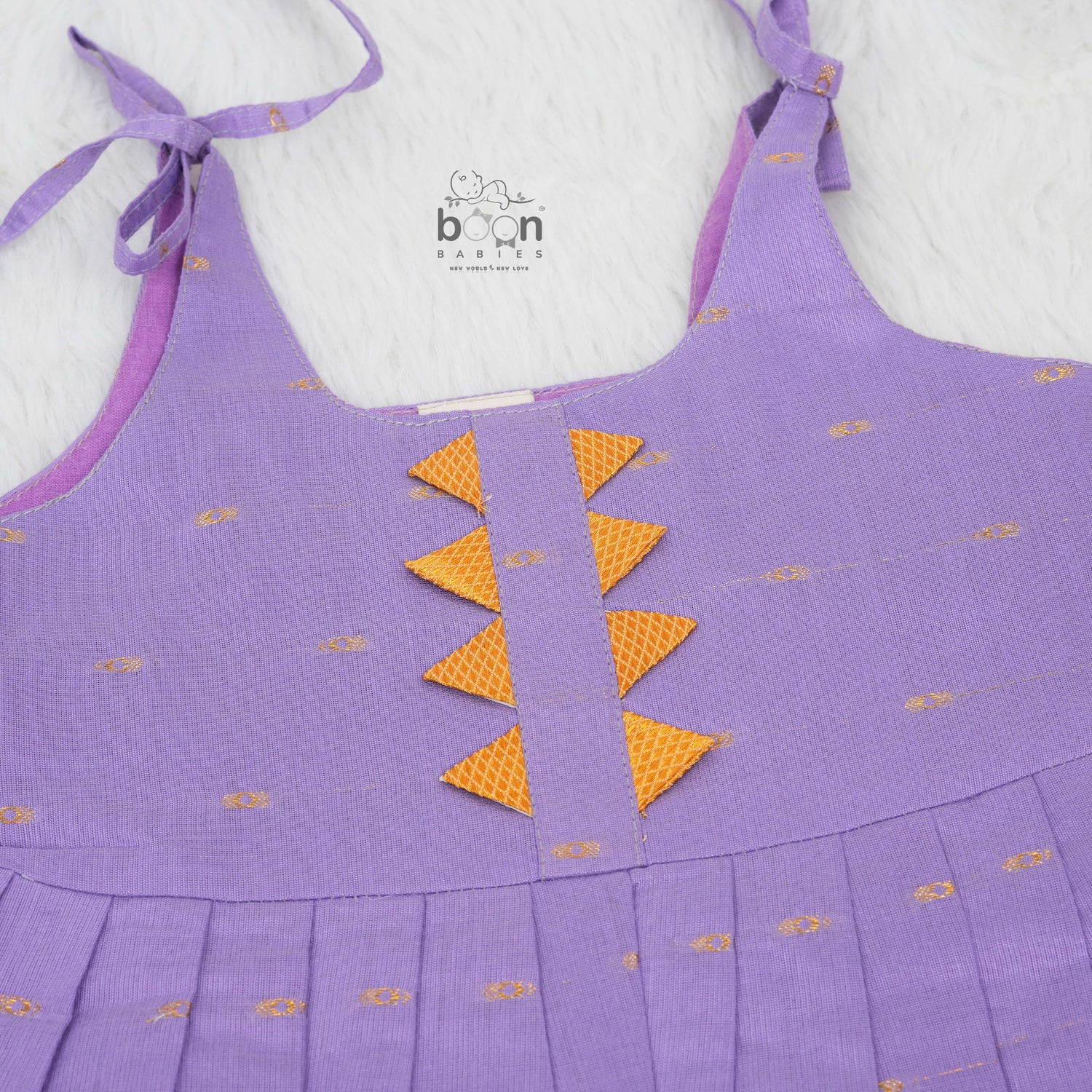 Festive purple silk Onam knot frock with triangle yoke design & zari border. Perfect for baby girls (0–12M).