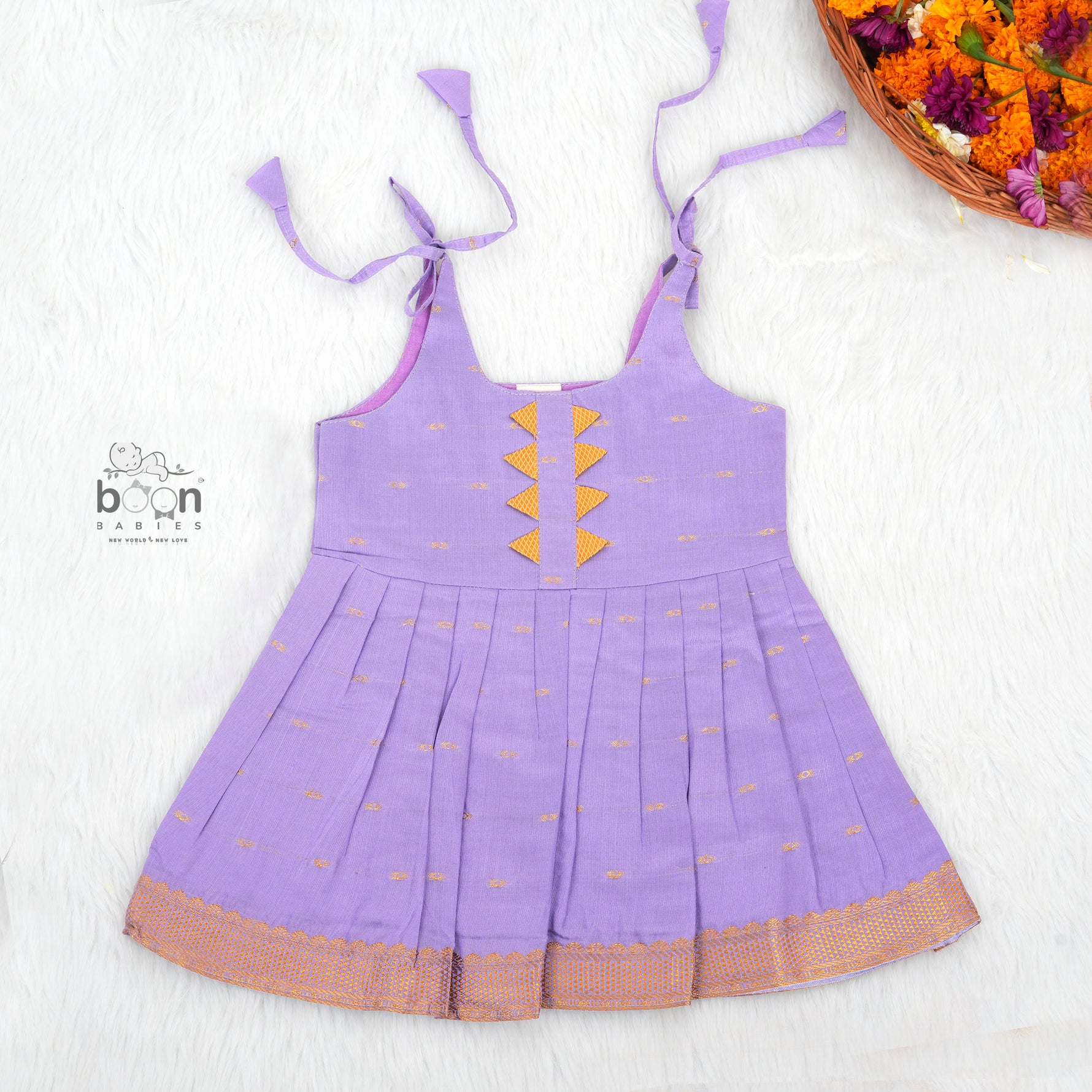 Festive purple silk Onam knot frock with triangle yoke design & zari border. Perfect for baby girls (0–12M).