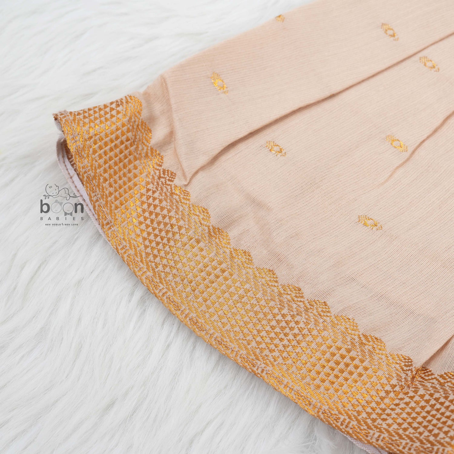 Beige silk Onam knot frock with zari border & triangle yoke. Ages 0–12M. Elegant festive outfit for baby girls.