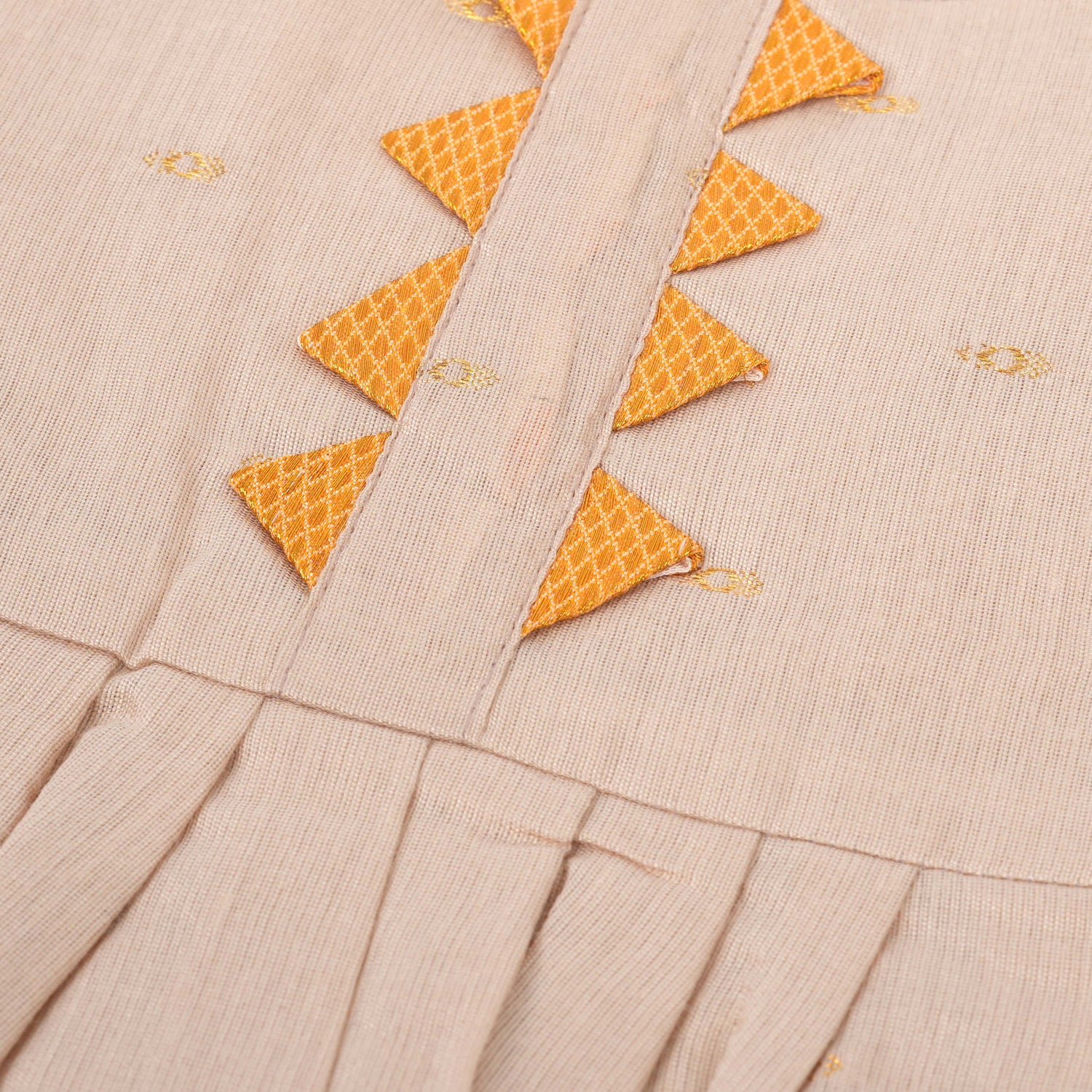 Beige silk Onam knot frock with zari border & triangle yoke. Ages 0–12M. Elegant festive outfit for baby girls.