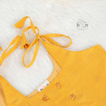 Mustard yellow silk knot frock with zari border for baby girls (0–12 months). Traditional, festive & comfortable.