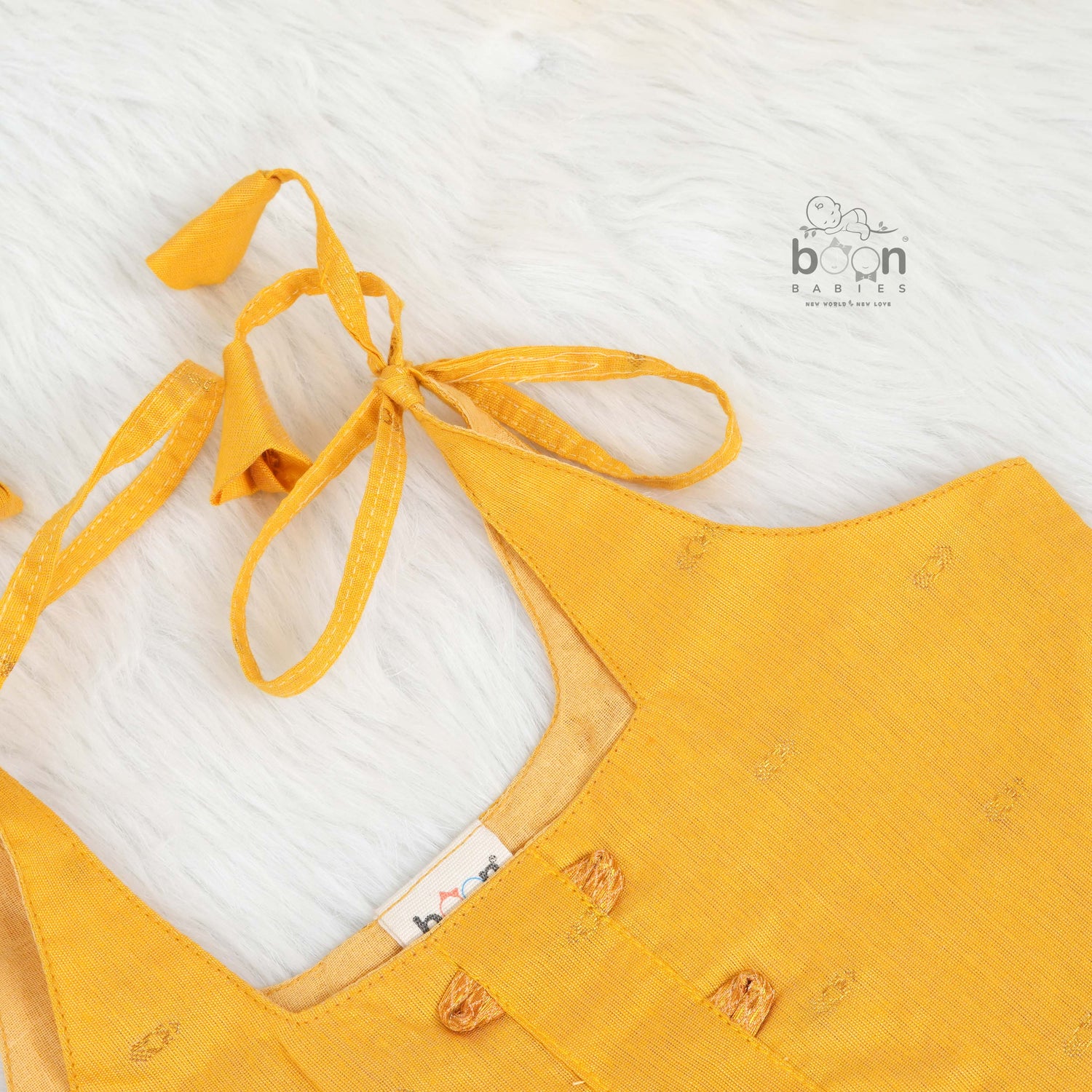 Mustard yellow silk knot frock with zari border for baby girls (0–12 months). Traditional, festive & comfortable.