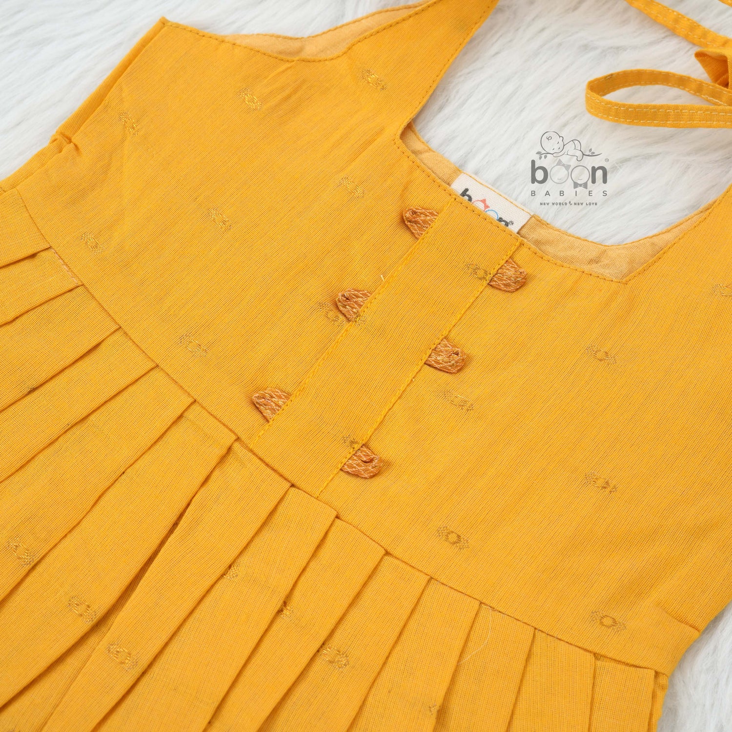Mustard yellow silk knot frock with zari border for baby girls (0–12 months). Traditional, festive & comfortable.