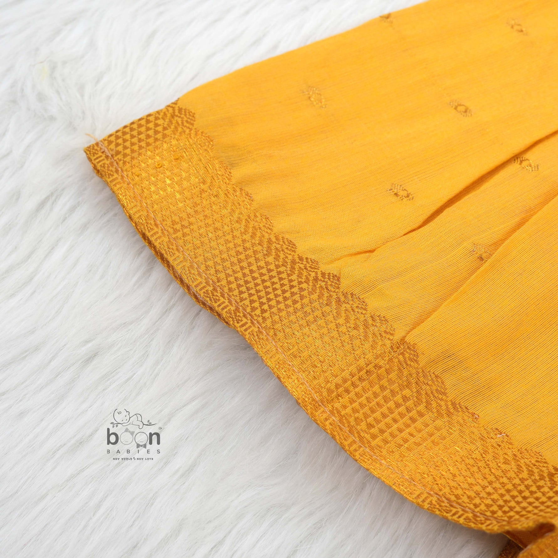 Bright yellow silk Onam knot frock with triangle yoke design & zari border. Perfect festive wear for baby girls (0–12M).