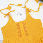 Bright yellow silk Onam knot frock with triangle yoke design & zari border. Perfect festive wear for baby girls (0–12M).