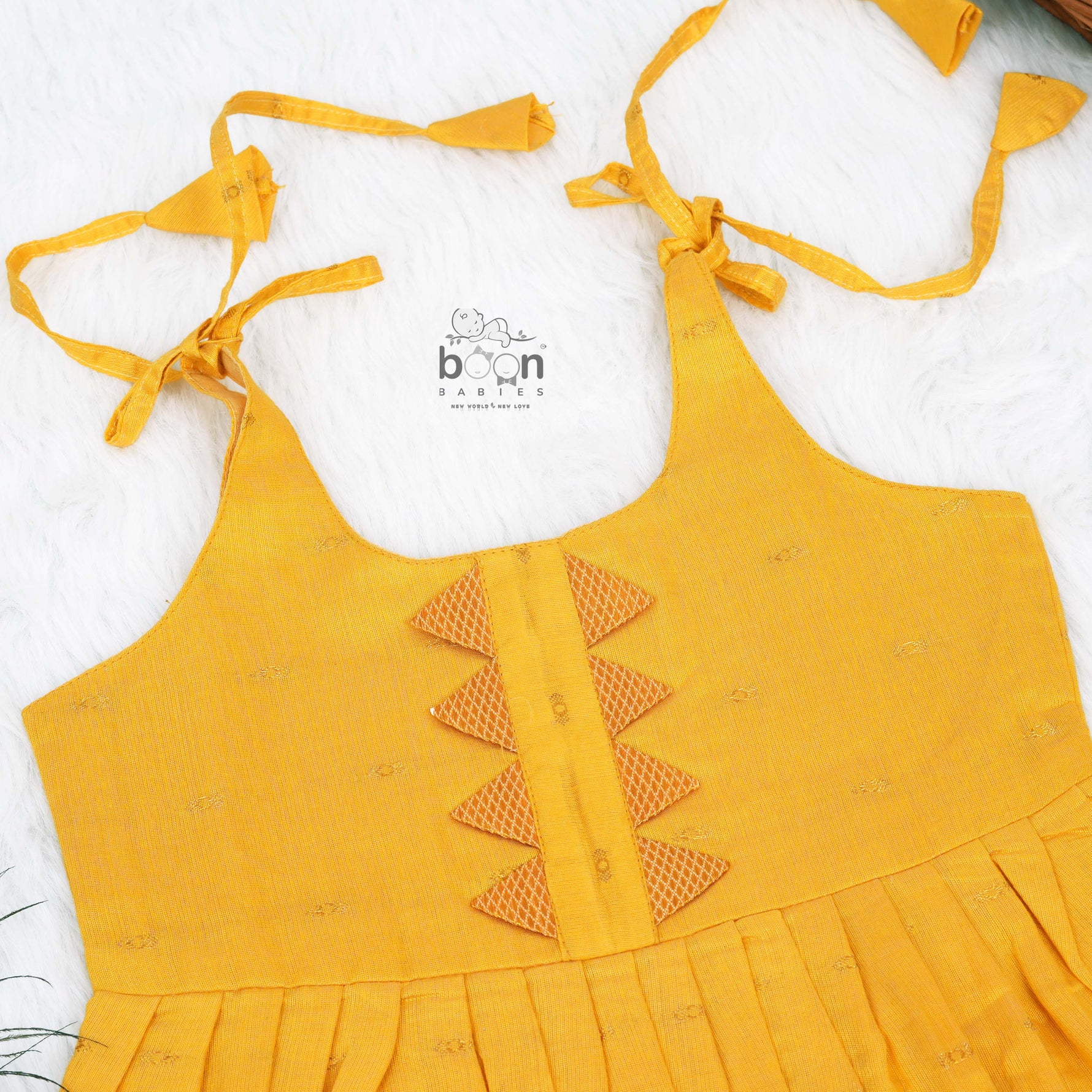 Bright yellow silk Onam knot frock with triangle yoke design & zari border. Perfect festive wear for baby girls (0–12M).