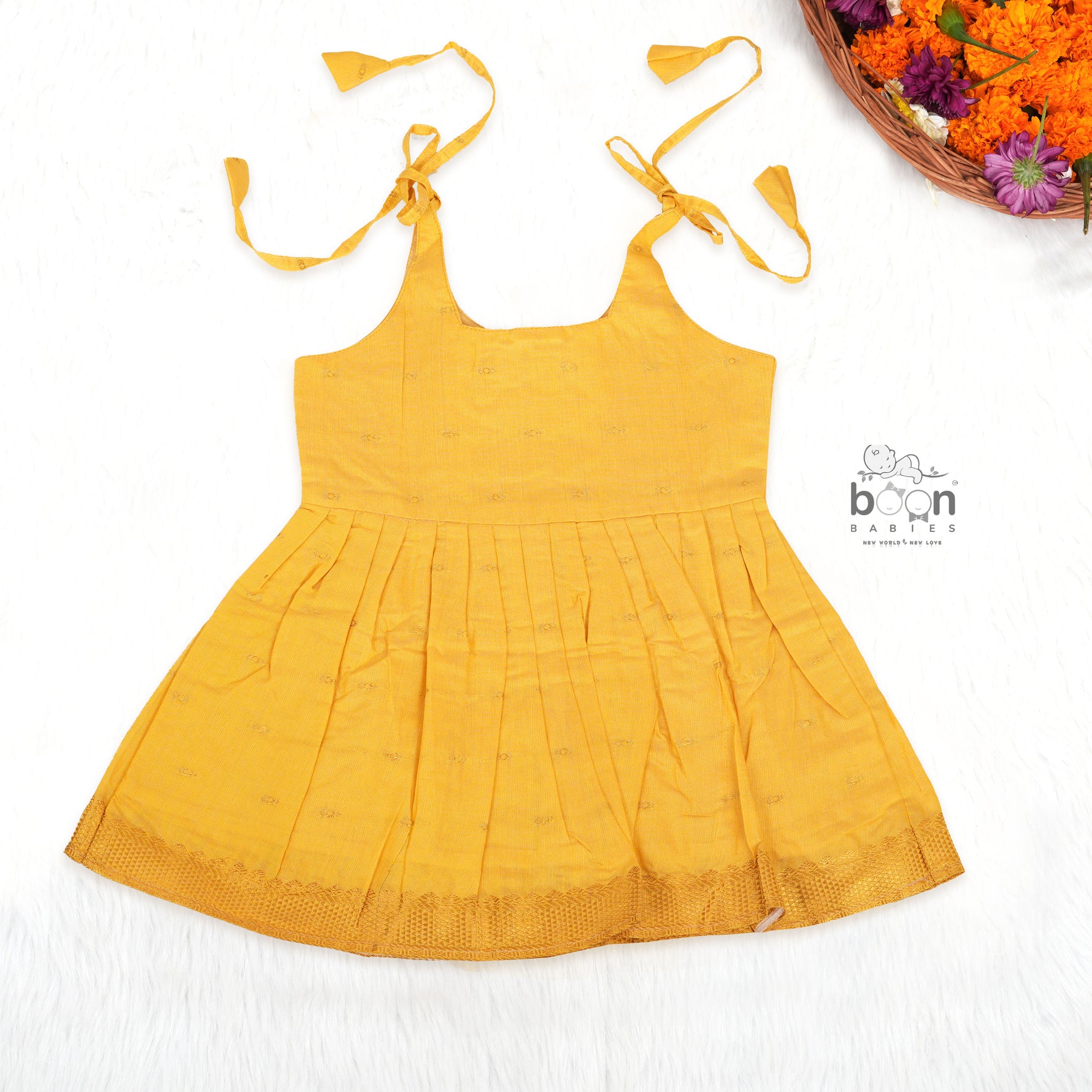 Bright yellow silk Onam knot frock with triangle yoke design & zari border. Perfect festive wear for baby girls (0–12M).