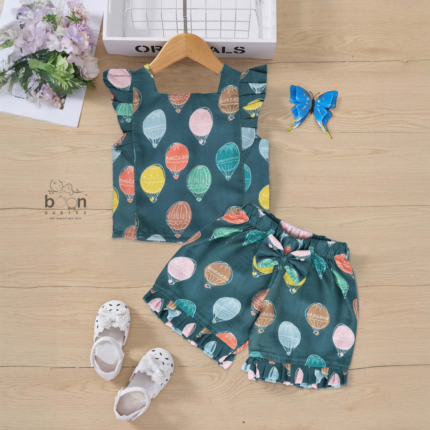 Cotton frill top & shorts set with teal base and multicolor hot air balloon print. Sizes 6M–5Y. Cute, comfy & playful casual wear for girls.
