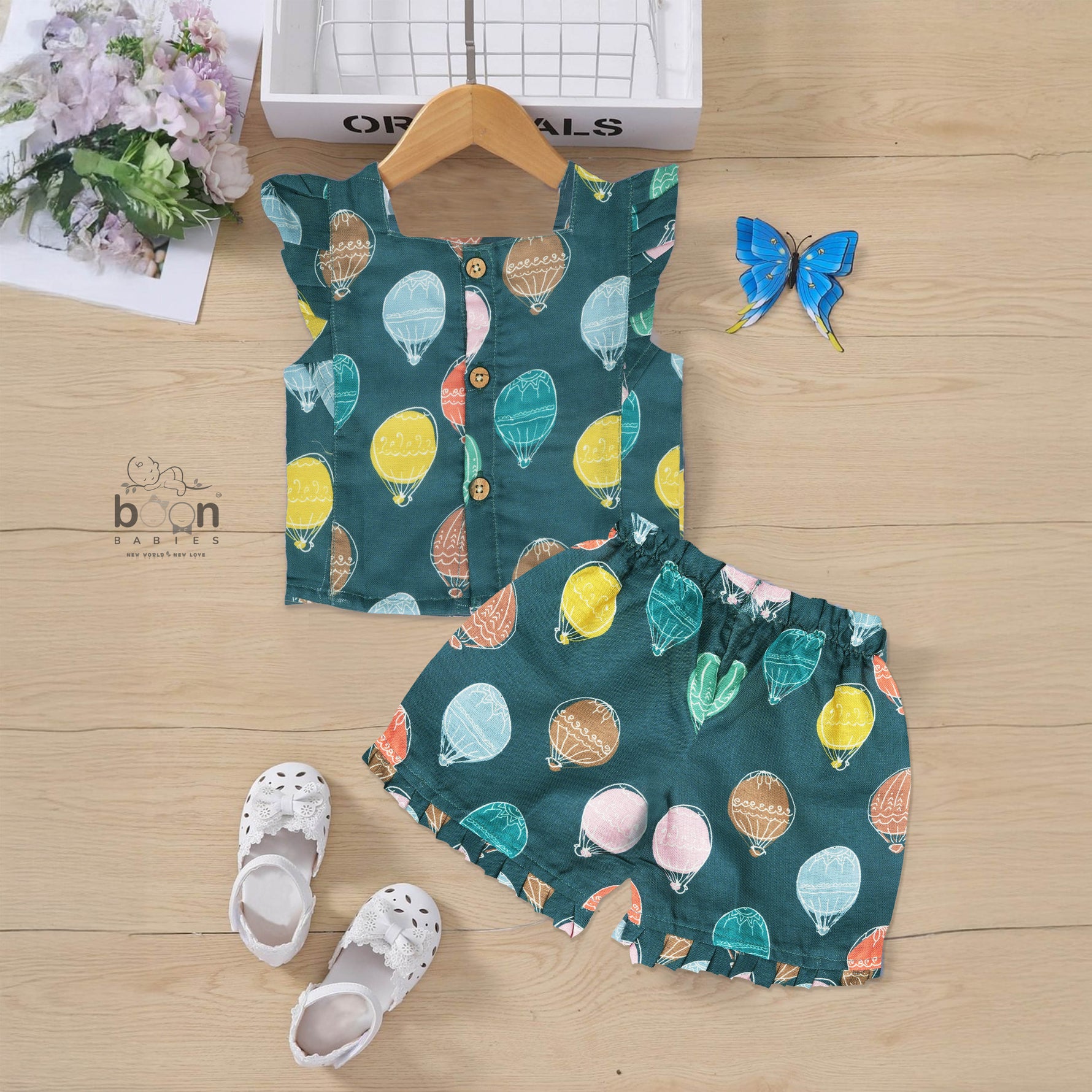 Cotton frill top & shorts set with teal base and multicolor hot air balloon print. Sizes 6M–5Y. Cute, comfy & playful casual wear for girls.

