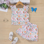 White cotton frill top with floral shorts. Ages 6M–5Y. Lightweight & stylish summer outfit for baby girls.
