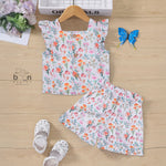White cotton frill top with floral shorts. Ages 6M–5Y. Lightweight & stylish summer outfit for baby girls.
