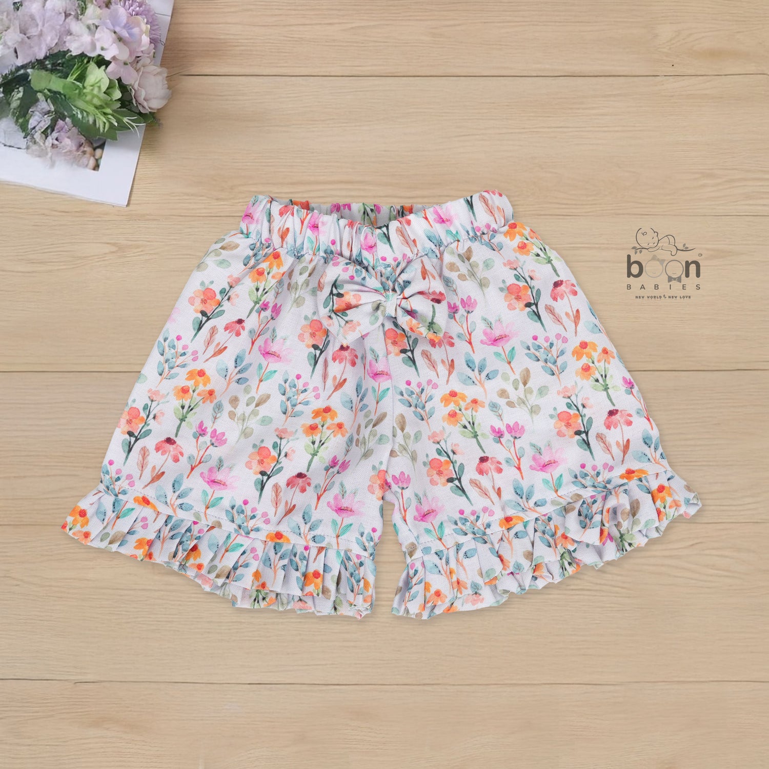 White cotton frill top with floral shorts. Ages 6M–5Y. Lightweight & stylish summer outfit for baby girls.
