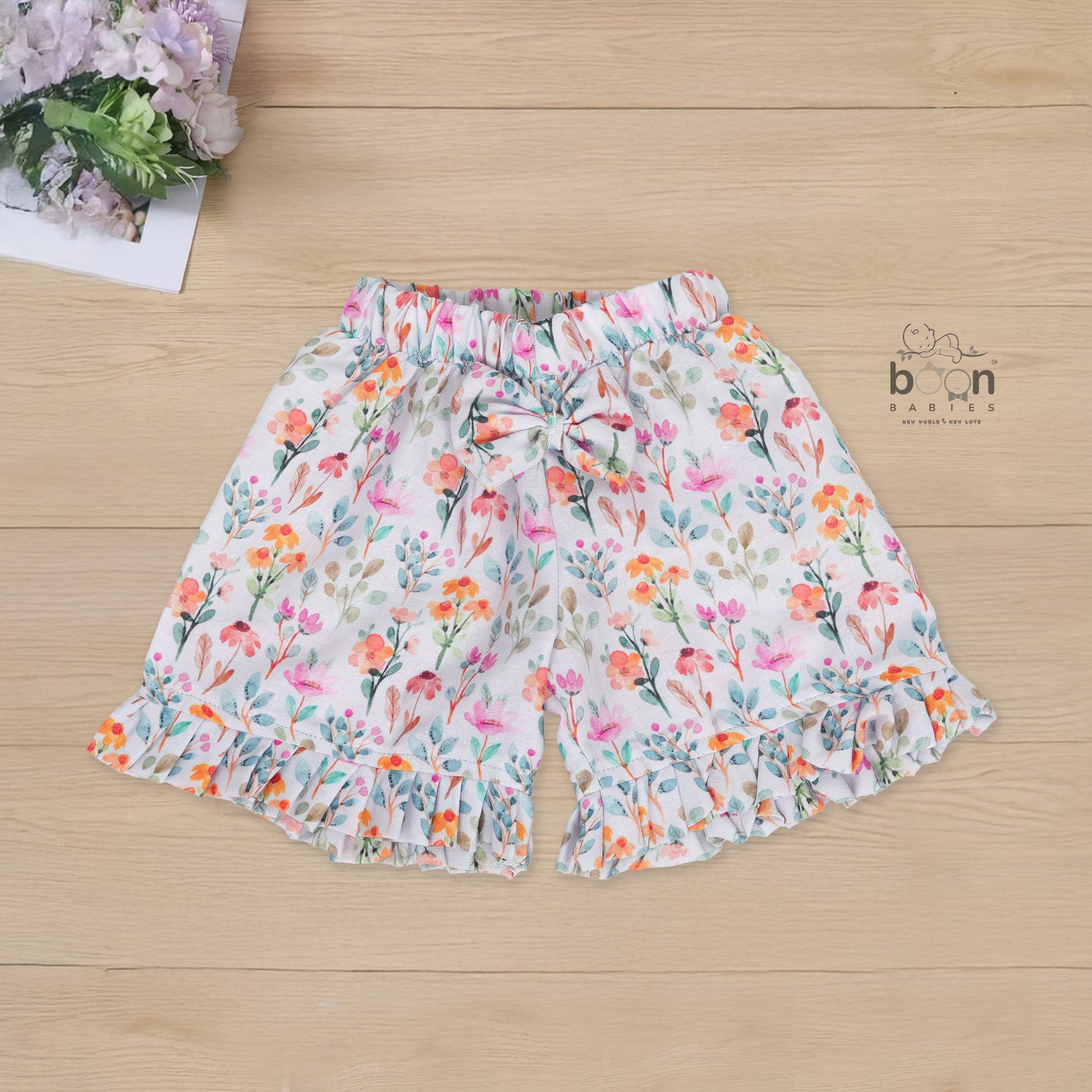 White cotton frill top with floral shorts. Ages 6M–5Y. Lightweight & stylish summer outfit for baby girls.
