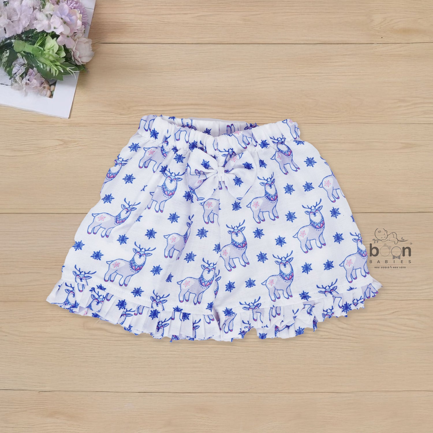 White cotton frill top & shorts set with blue reindeer print. Ages 6M–5Y. Cute, comfy & festive casual wear for baby girls