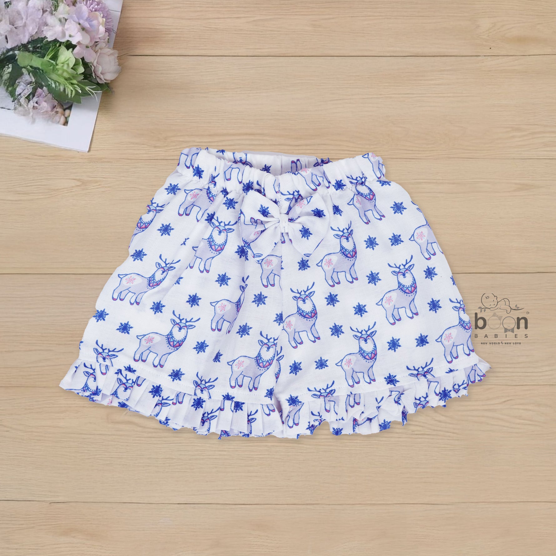 White cotton frill top & shorts set with blue reindeer print. Ages 6M–5Y. Cute, comfy & festive casual wear for baby girls