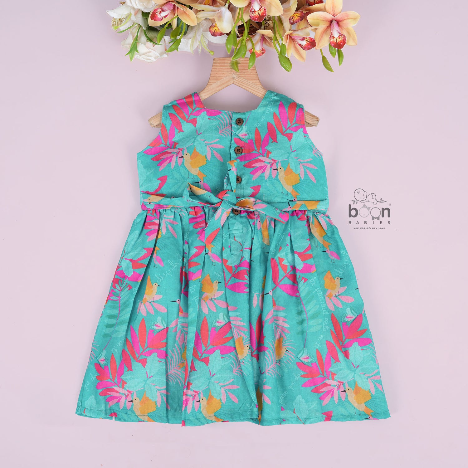 Aqua blue sleeveless frock for girls aged 1 to 4 years, made of slub cotton with colorful tropical bird and leaf print – from Boon Babies, Coimbatore.