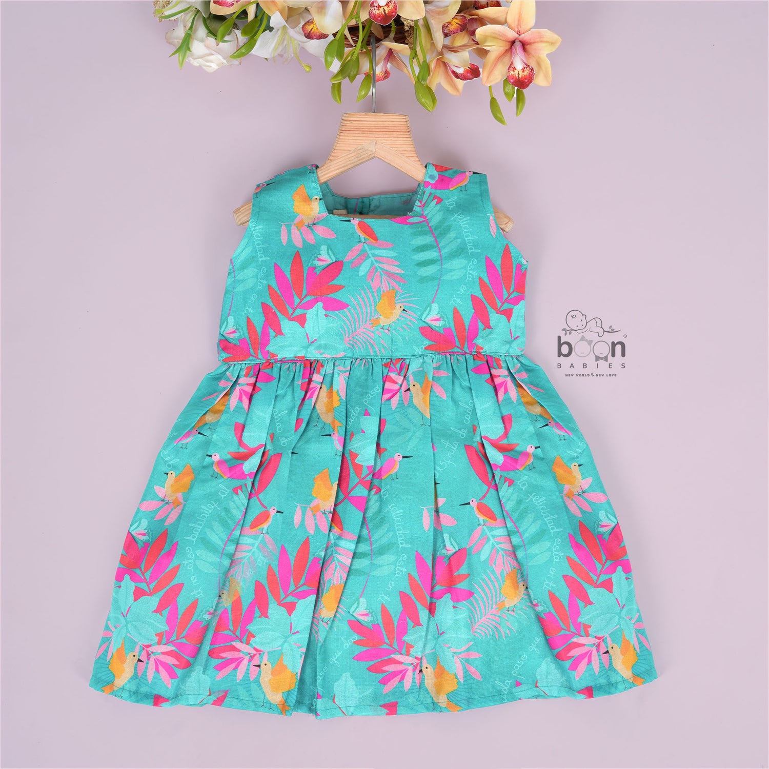 Aqua blue sleeveless frock for girls aged 1 to 4 years, made of slub cotton with colorful tropical bird and leaf print – from Boon Babies, Coimbatore.