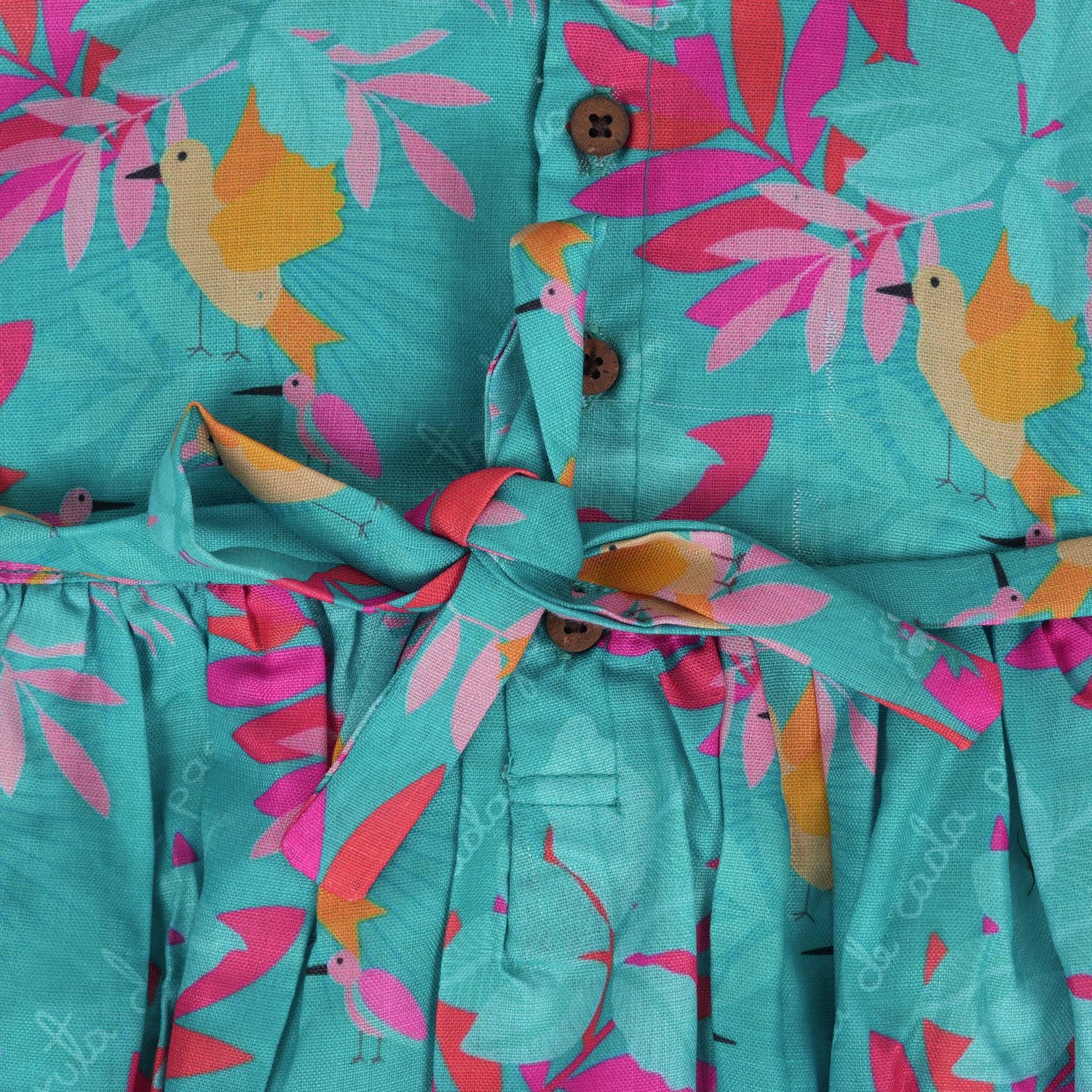 Aqua blue sleeveless frock for girls aged 1 to 4 years, made of slub cotton with colorful tropical bird and leaf print – from Boon Babies, Coimbatore.