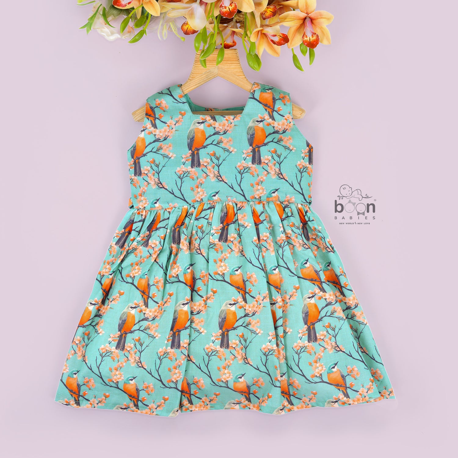 Sleeveless aqua frock with orange birds and peach blossoms printed on soft slub cotton fabric – suitable for girls aged 1 to 4 years from Boon Babies, Coimbatore.