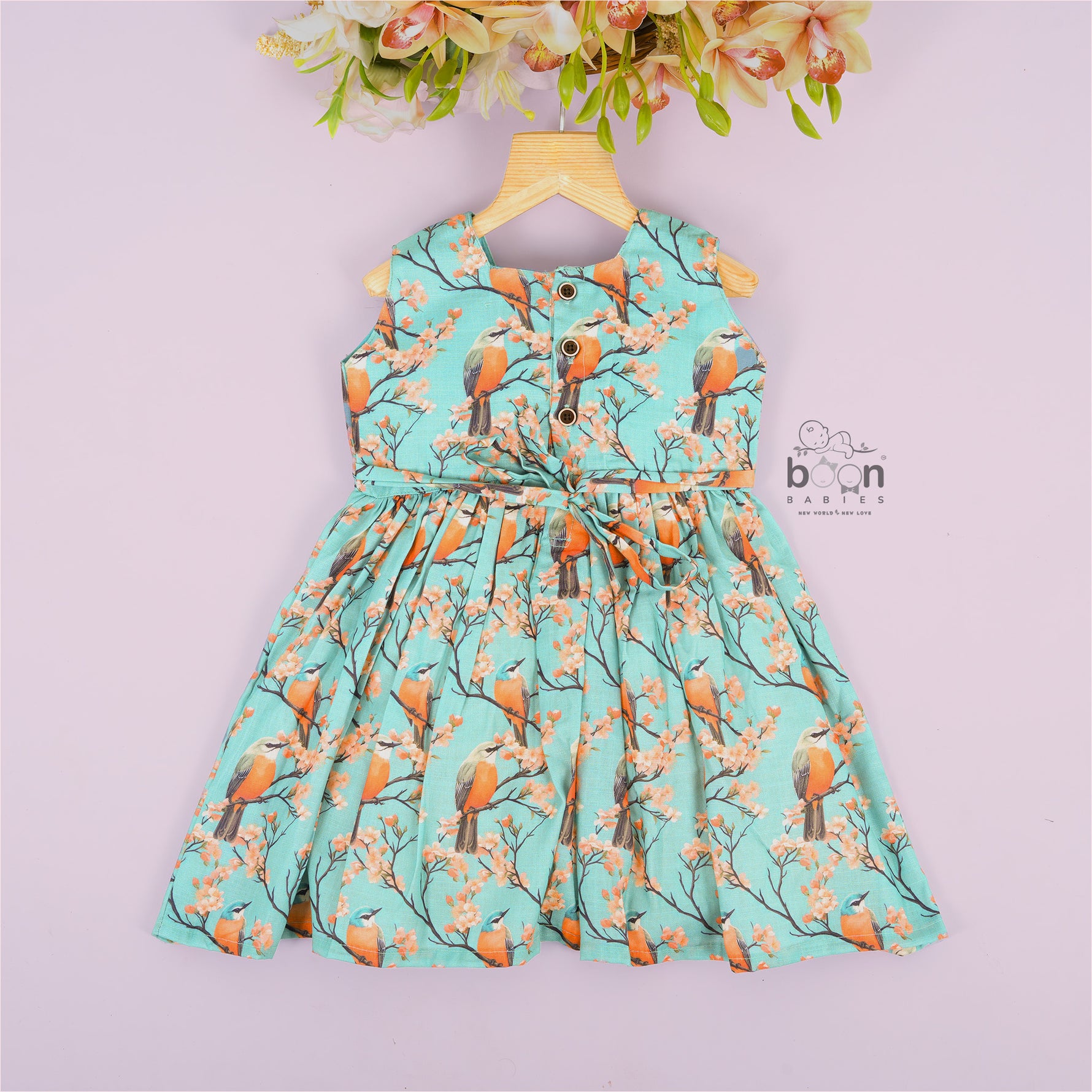 Sleeveless aqua frock with orange birds and peach blossoms printed on soft slub cotton fabric – suitable for girls aged 1 to 4 years from Boon Babies, Coimbatore.