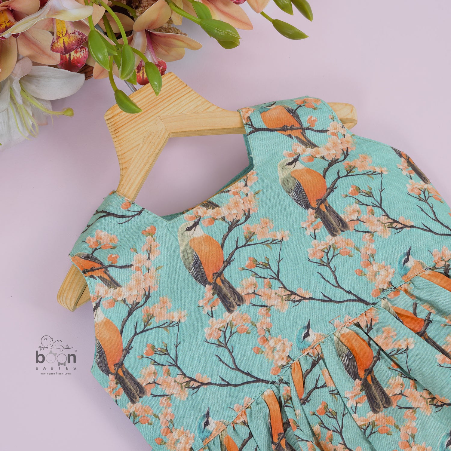 Sleeveless aqua frock with orange birds and peach blossoms printed on soft slub cotton fabric – suitable for girls aged 1 to 4 years from Boon Babies, Coimbatore.