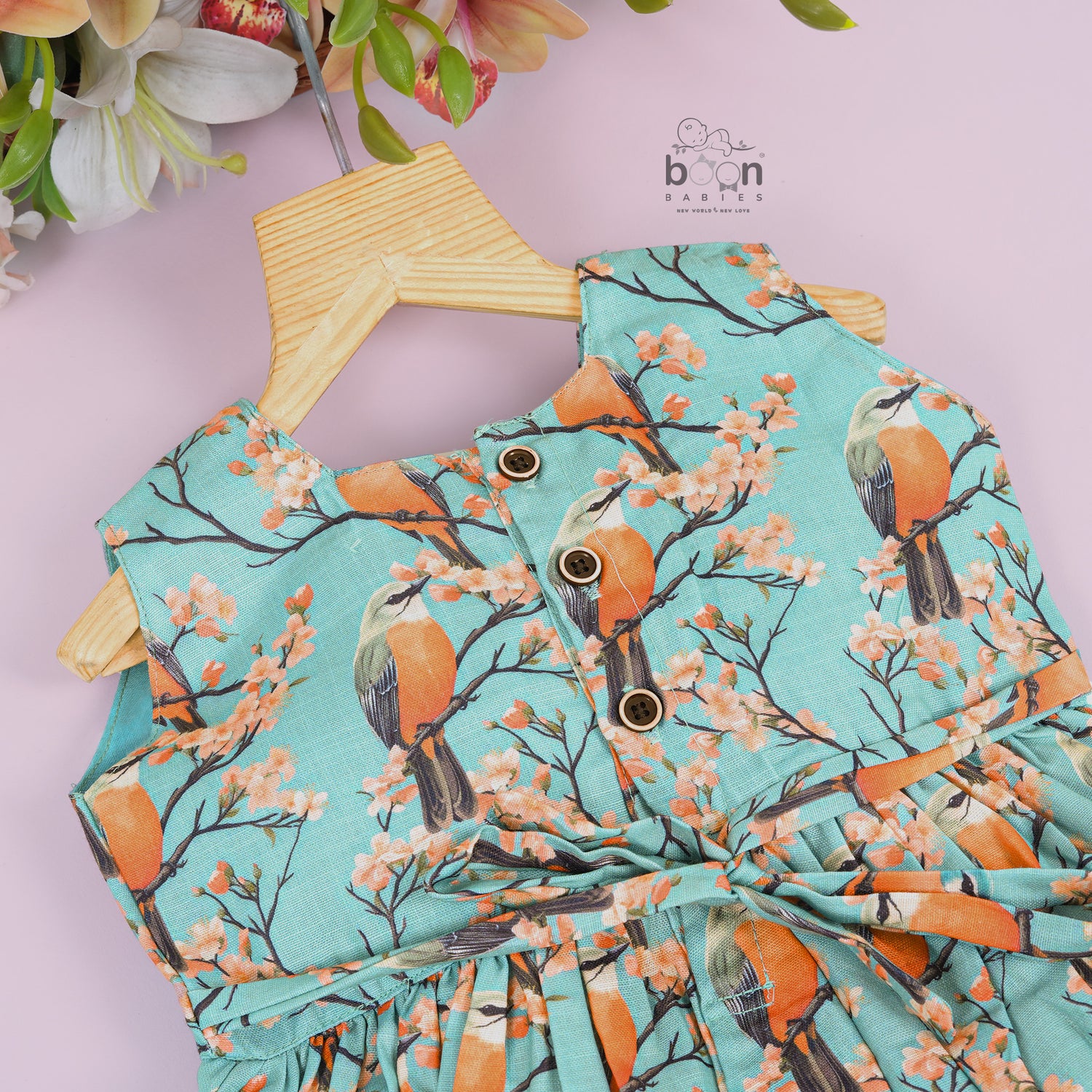 Sleeveless aqua frock with orange birds and peach blossoms printed on soft slub cotton fabric – suitable for girls aged 1 to 4 years from Boon Babies, Coimbatore.