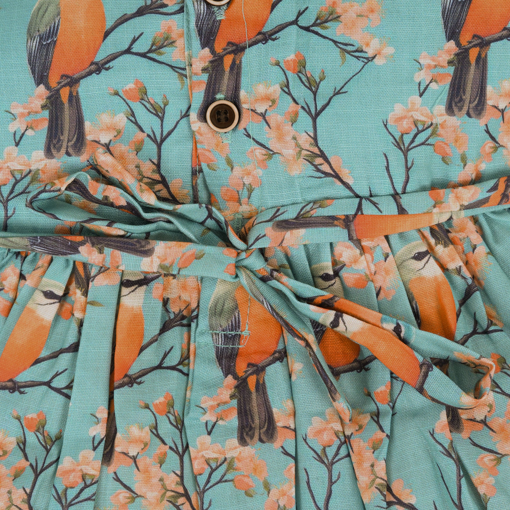 Sleeveless aqua frock with orange birds and peach blossoms printed on soft slub cotton fabric – suitable for girls aged 1 to 4 years from Boon Babies, Coimbatore.