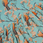 Sleeveless aqua frock with orange birds and peach blossoms printed on soft slub cotton fabric – suitable for girls aged 1 to 4 years from Boon Babies, Coimbatore.