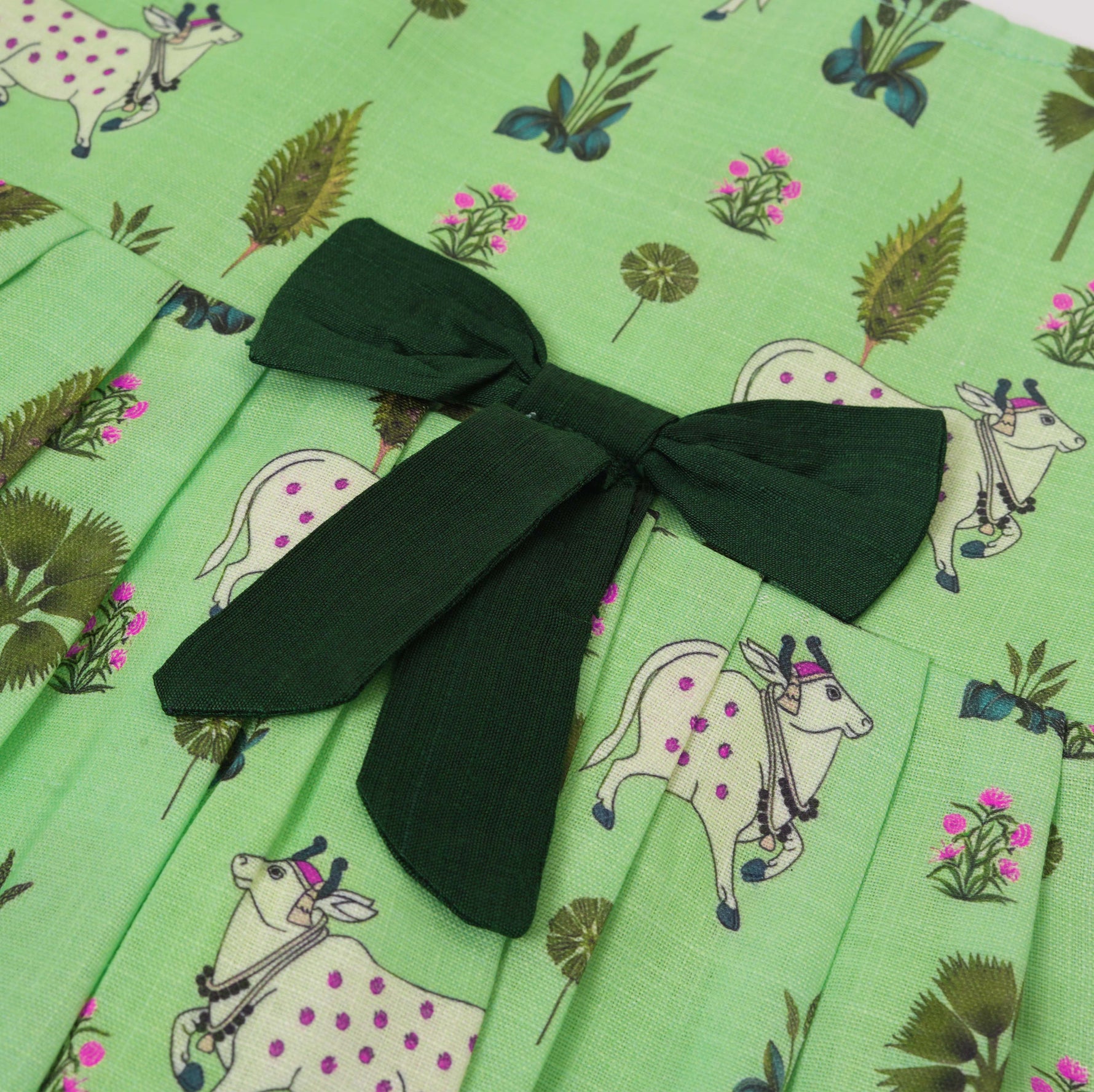 Cute sleeveless cotton frock in green with deer & floral prints. Ages 1–4 years. Soft, breathable & perfect for festive and casual looks.