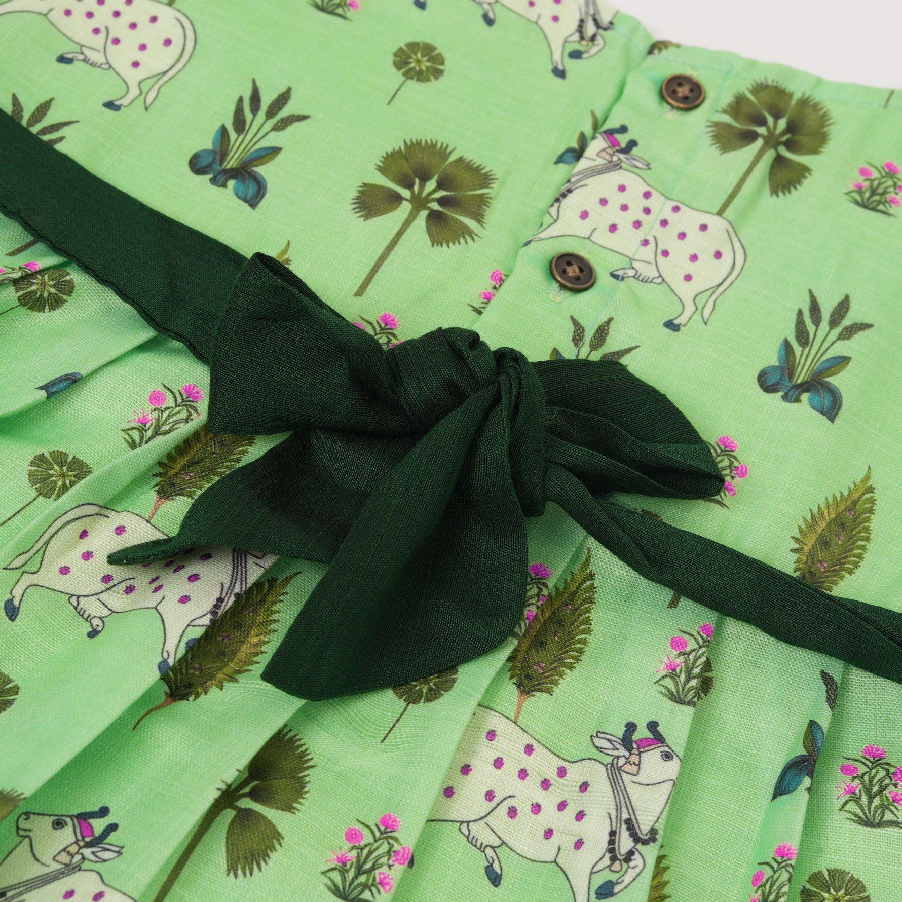 Cute sleeveless cotton frock in green with deer & floral prints. Ages 1–4 years. Soft, breathable & perfect for festive and casual looks.