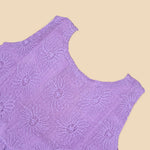 Lilac sleeveless Hakoba frock for baby girls, featuring floral embroidery and soft pleats, displayed flat on a beige background with a decorative heart and flowers.