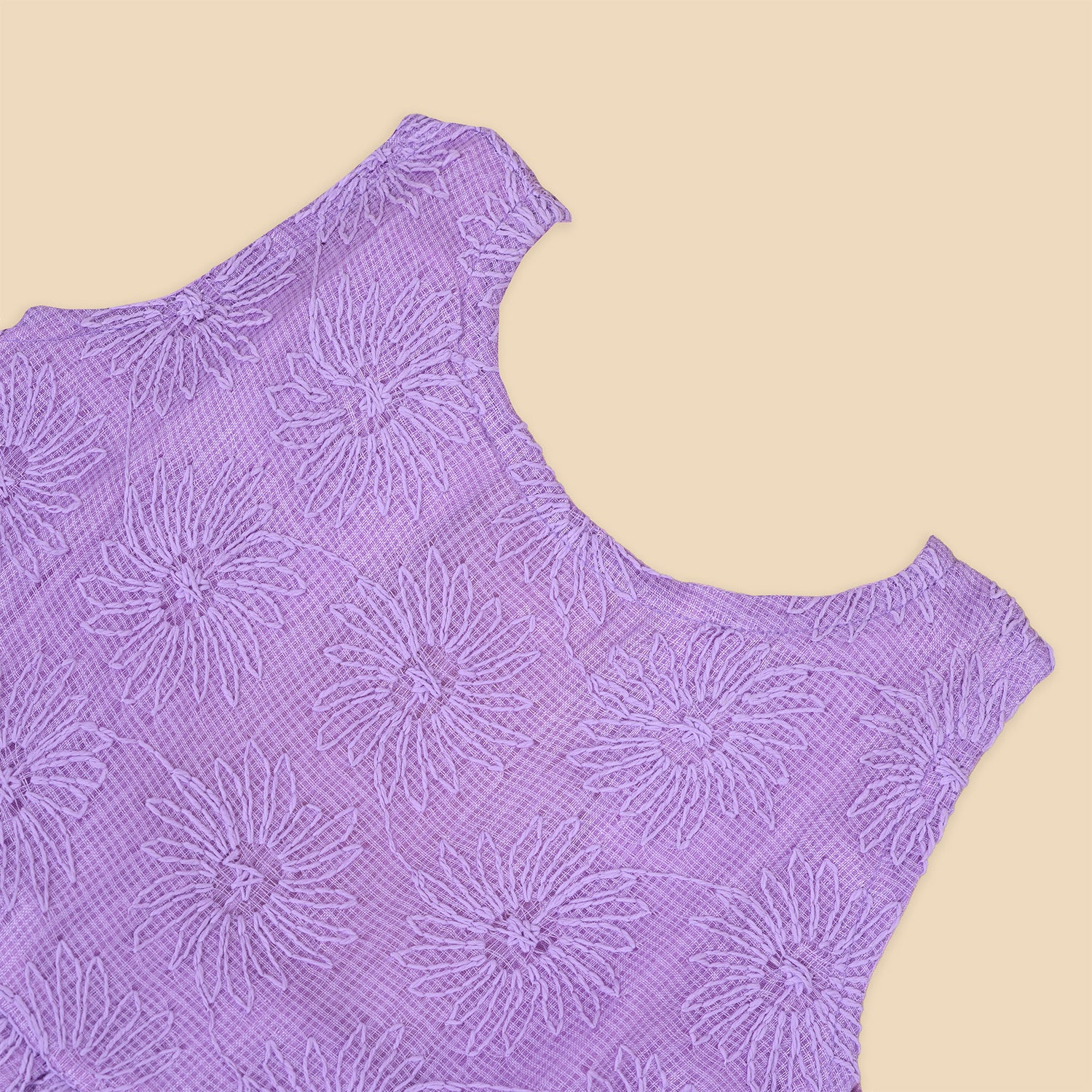 Lilac sleeveless Hakoba frock for baby girls, featuring floral embroidery and soft pleats, displayed flat on a beige background with a decorative heart and flowers.