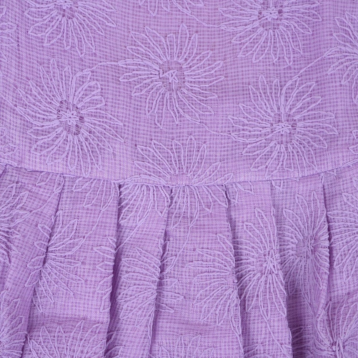 Lilac sleeveless Hakoba frock for baby girls, featuring floral embroidery and soft pleats, displayed flat on a beige background with a decorative heart and flowers.