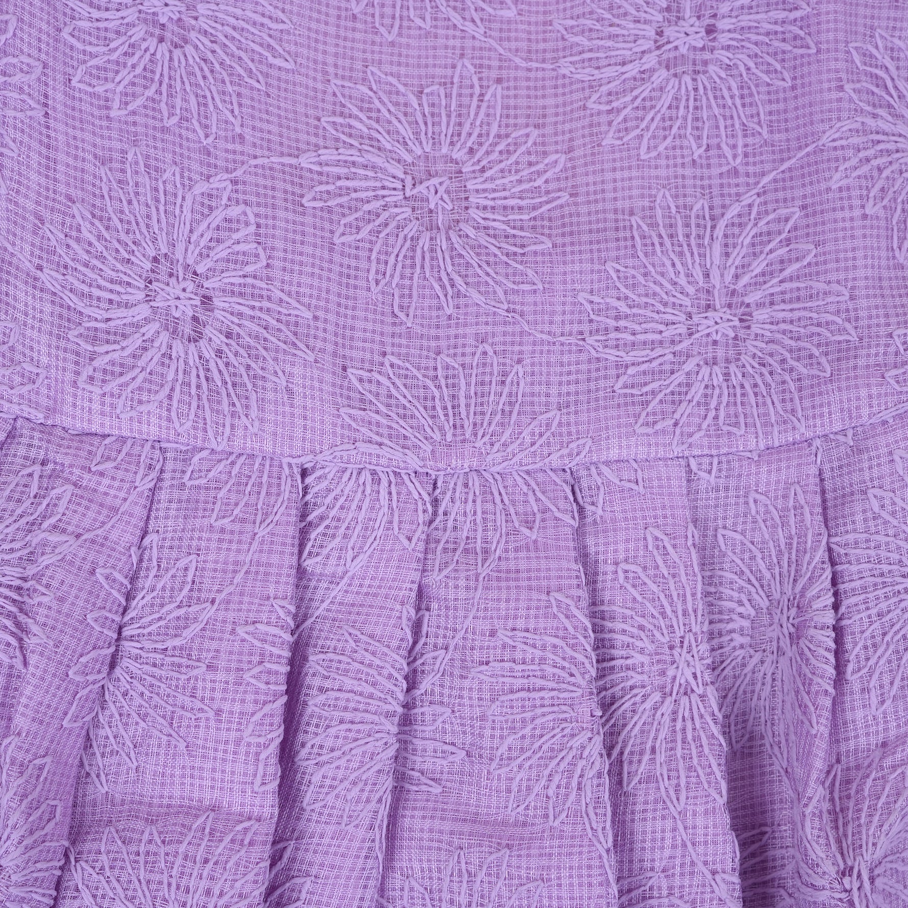 Lilac sleeveless Hakoba frock for baby girls, featuring floral embroidery and soft pleats, displayed flat on a beige background with a decorative heart and flowers.