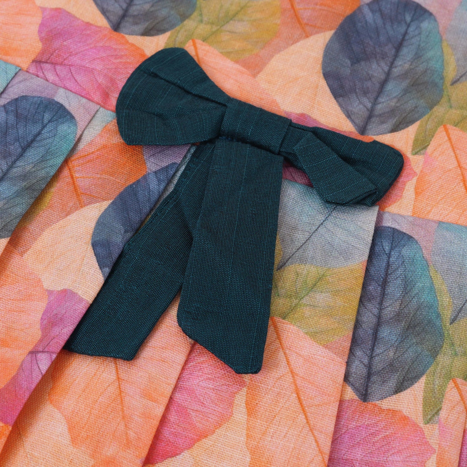 Colorful sleeveless cotton frock with multicolor leaf prints & bow. Ages 1–4 years. Perfect for festive outings, birthdays & everyday cuteness.