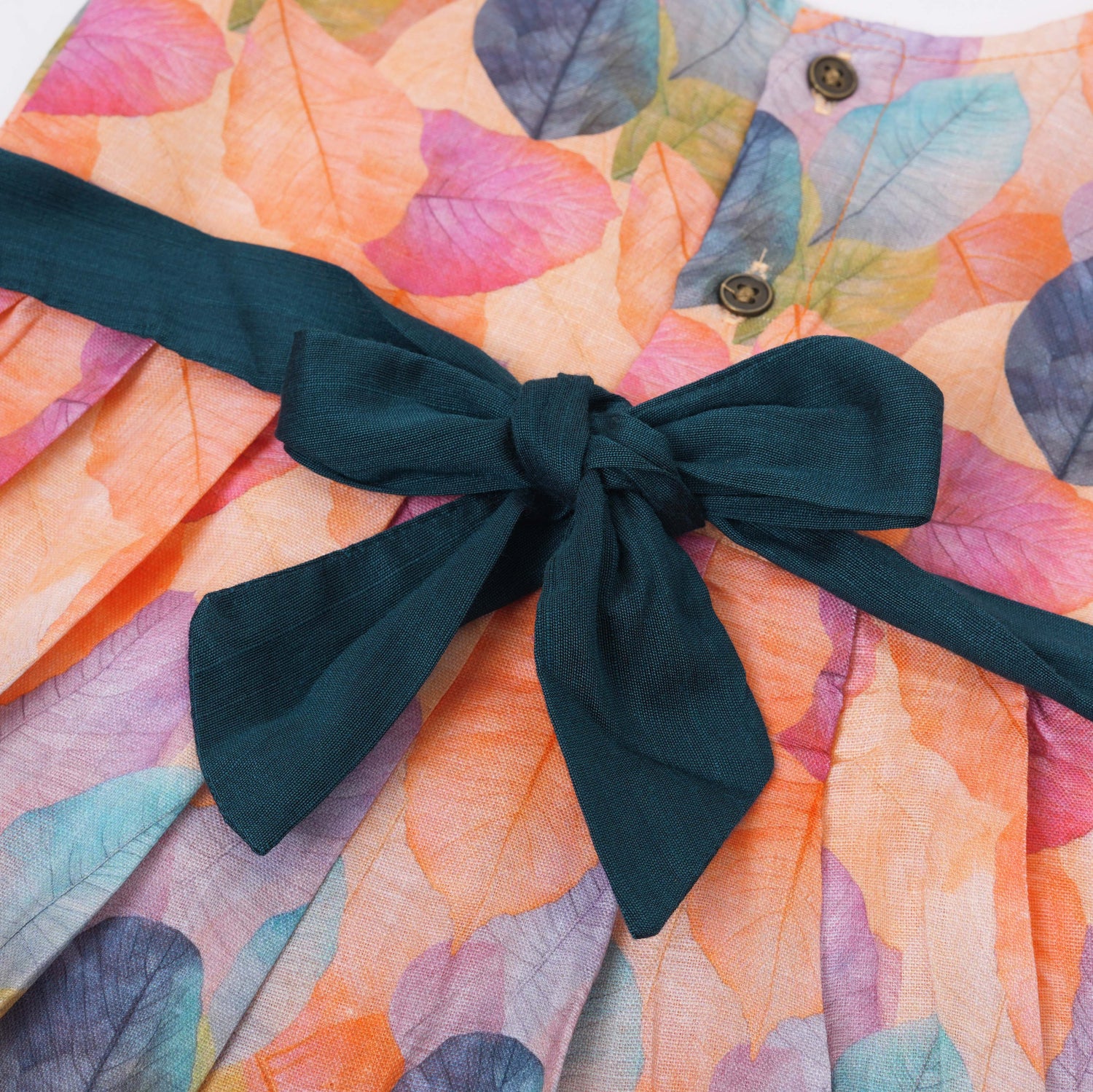 Colorful sleeveless cotton frock with multicolor leaf prints & bow. Ages 1–4 years. Perfect for festive outings, birthdays & everyday cuteness.