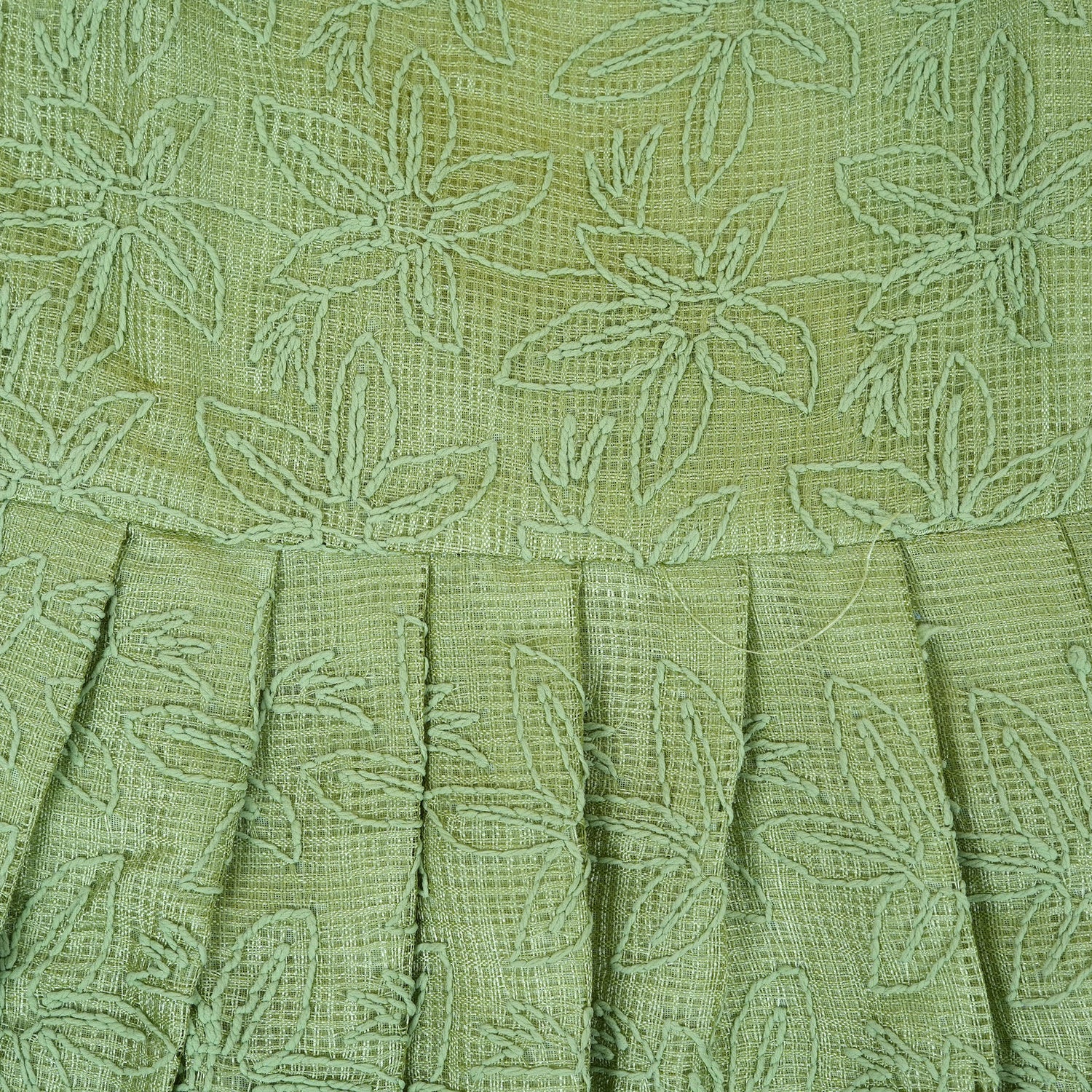 Pastel green sleeveless Hakoba frock for baby girls, featuring floral embroidery and pleated skirt design. Lightweight cotton fabric, displayed flat against a soft beige background with a decorative heart and flowers.