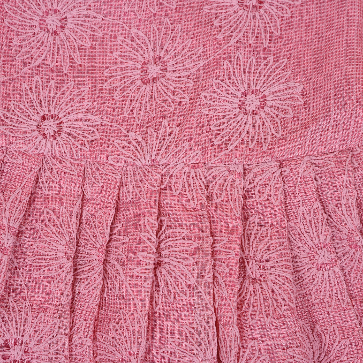 Pink sleeveless Hakoba frock for baby girls, featuring floral embroidery and pleated skirt design, laid flat on a beige background with soft floral props.