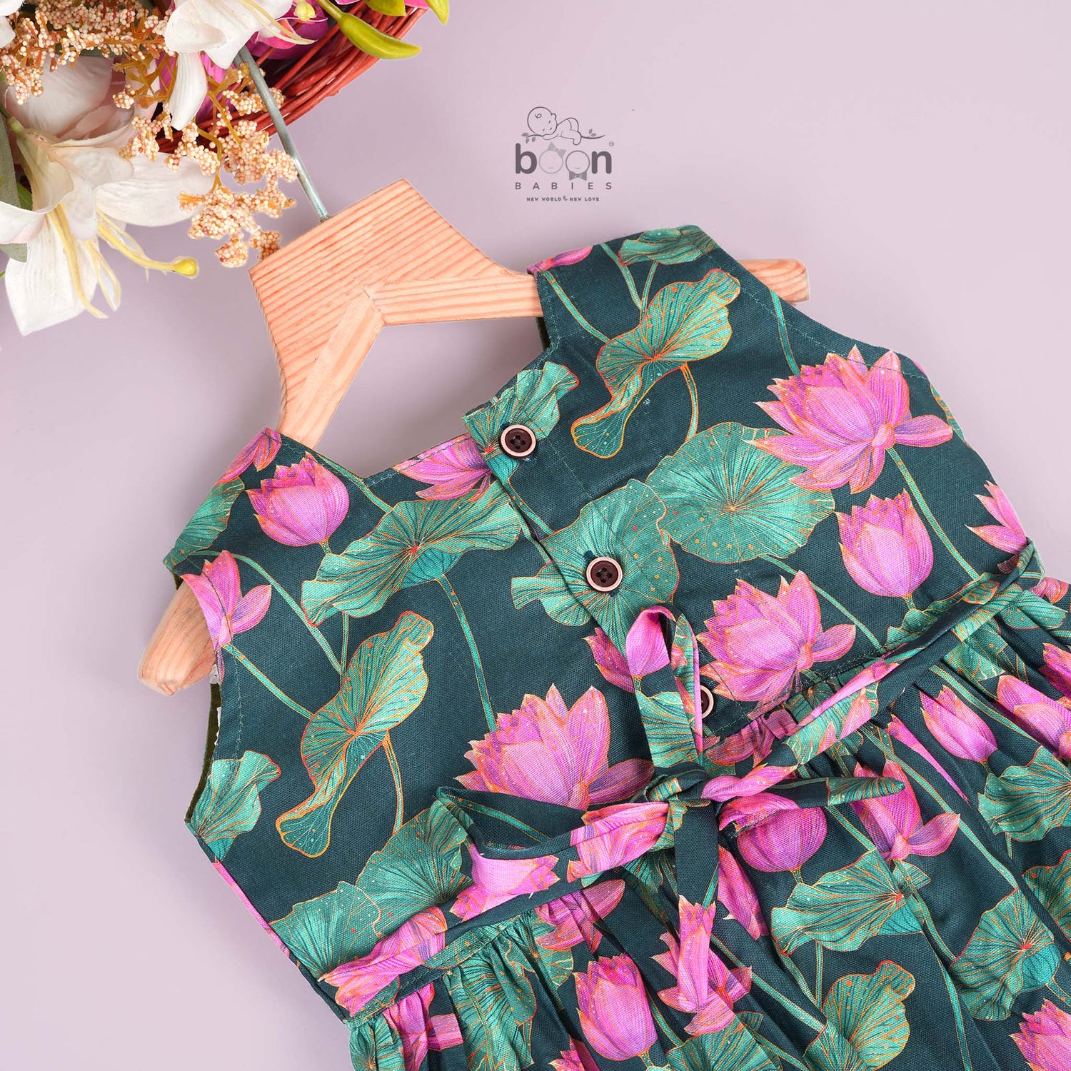 Sleeveless dark green frock for girls aged 1 to 4 years, featuring pink lotus floral print in slub cotton – from Boon Babies, Coimbatore.