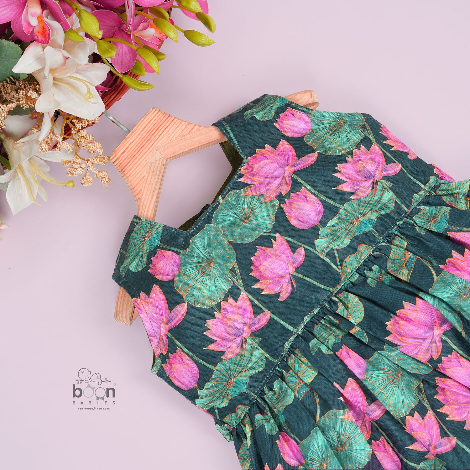 Sleeveless dark green frock for girls aged 1 to 4 years, featuring pink lotus floral print in slub cotton – from Boon Babies, Coimbatore.
