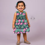 Sleeveless dark green frock for girls aged 1 to 4 years, featuring pink lotus floral print in slub cotton – from Boon Babies, Coimbatore.