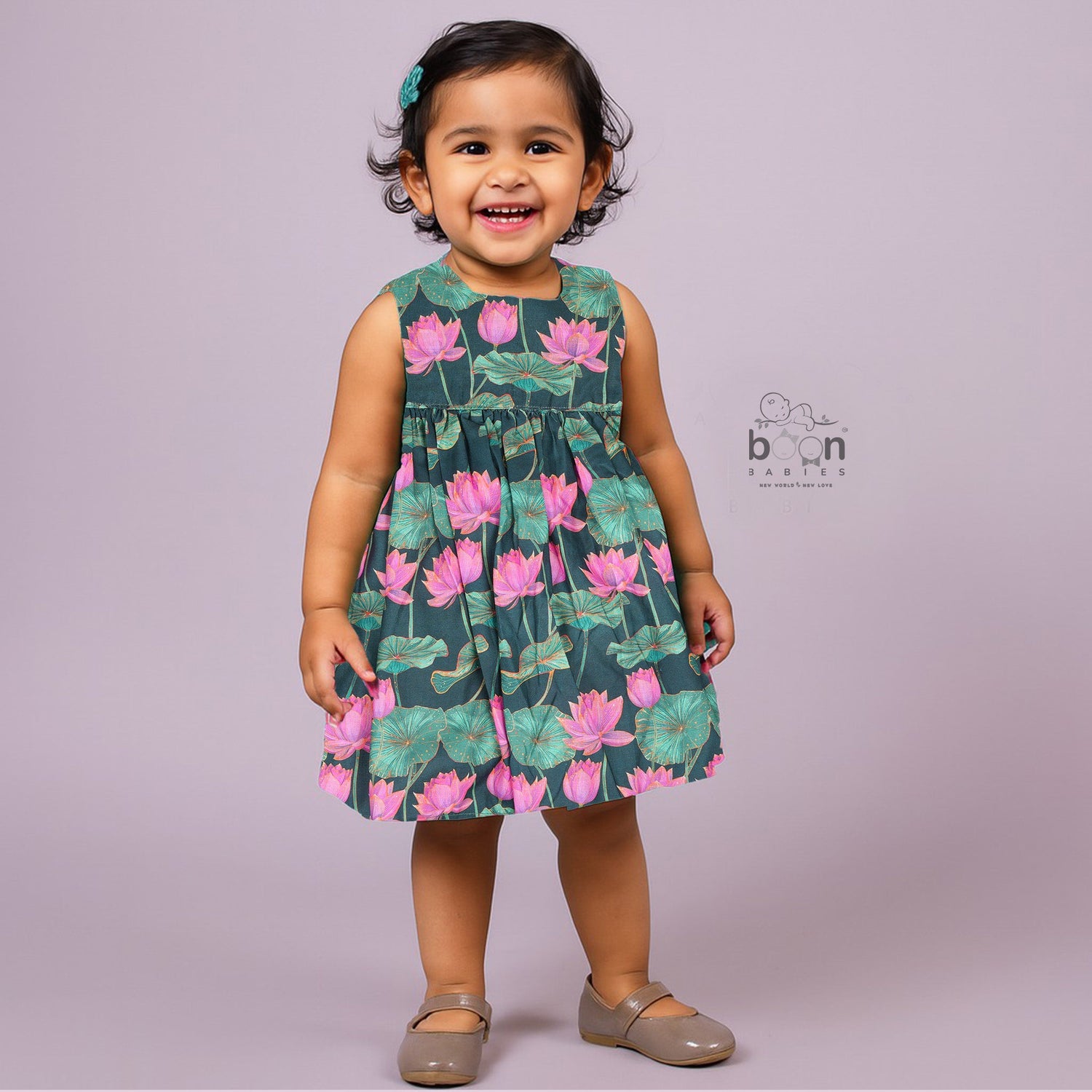 Sleeveless dark green frock for girls aged 1 to 4 years, featuring pink lotus floral print in slub cotton – from Boon Babies, Coimbatore.