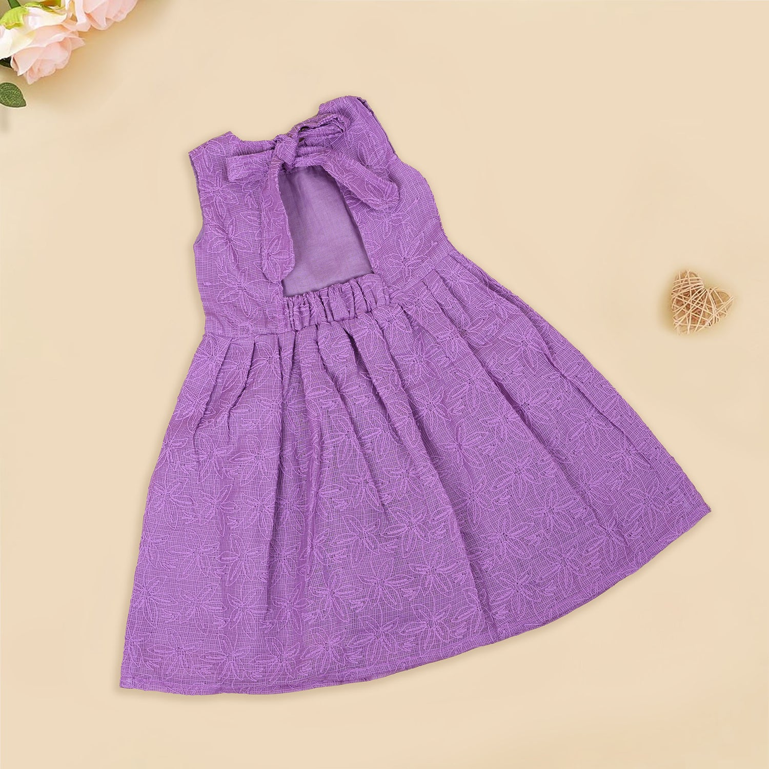 Orchid purple Hakoba frock for baby girls, sleeveless with floral embroidery and pleated skirt, displayed flat on beige background with soft props.