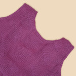 Wine-colored Hakoba frock for baby girls with sleeveless cut, floral embroidery, and pleated skirt design, laid flat on a beige background with floral props.