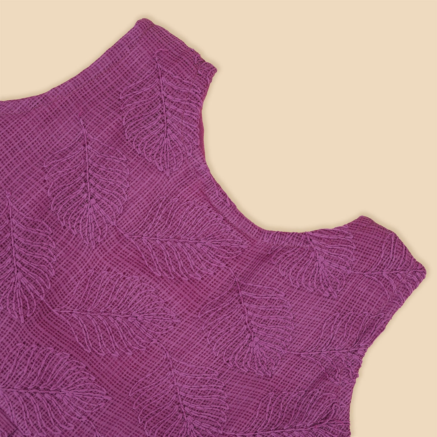 Wine-colored Hakoba frock for baby girls with sleeveless cut, floral embroidery, and pleated skirt design, laid flat on a beige background with floral props.