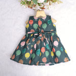 Little girl in a sleeveless denim blue frock with colorful balloon prints, made of slub cotton – part of Boon Babies babywear collection in Coimbatore.